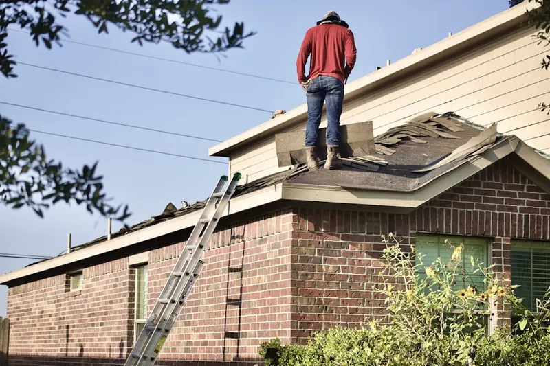 Professional roofer working on a residential roof in Floyd